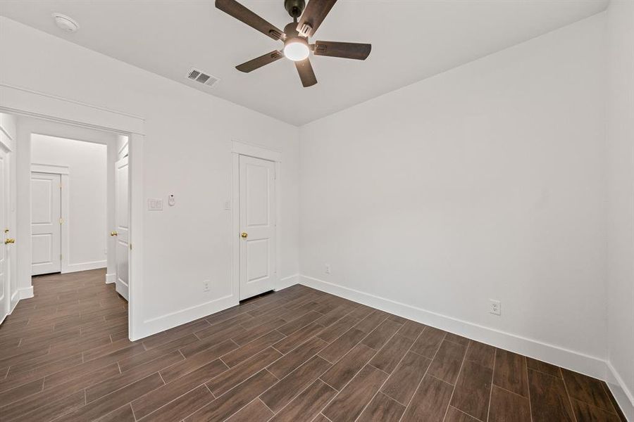 Unfurnished bedroom with wood tiled floors and ceiling fan Unfurnished bedroom with wood tiled floors and ceiling fan