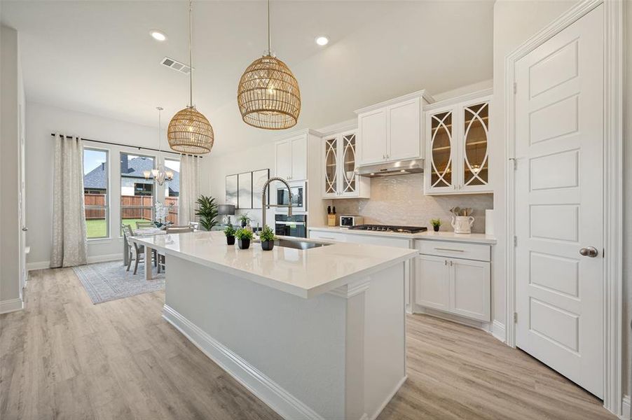 This beautifully appointed gourmet kitchen combines timeless elegance with modern functionality. Anchored by an expansive quartz island, the space features double ovens, stainless steel appliances, designer lighting, and extensive storage. The seamless connection to the dining and living areas creates an exceptional setting for entertaining and everyday living This beautifully appointed gourmet kitchen combines timeless elegance with modern functionality. Anchored by an expansive quartz island, the space features double ovens, stainless steel appliances, designer lighting, and extensive storage. The seamless connection to the dining and living areas creates an exceptional setting for entertaining and everyday living