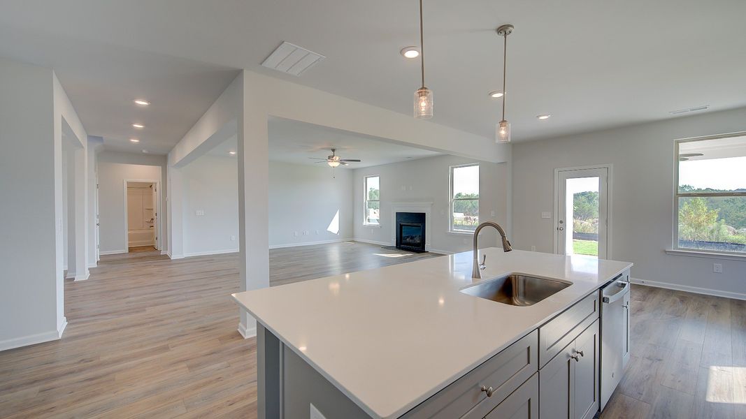 McKinley II open-concept kitchen with large island overlooking breakfast area and family room at Brighton in Locust Grove, GA