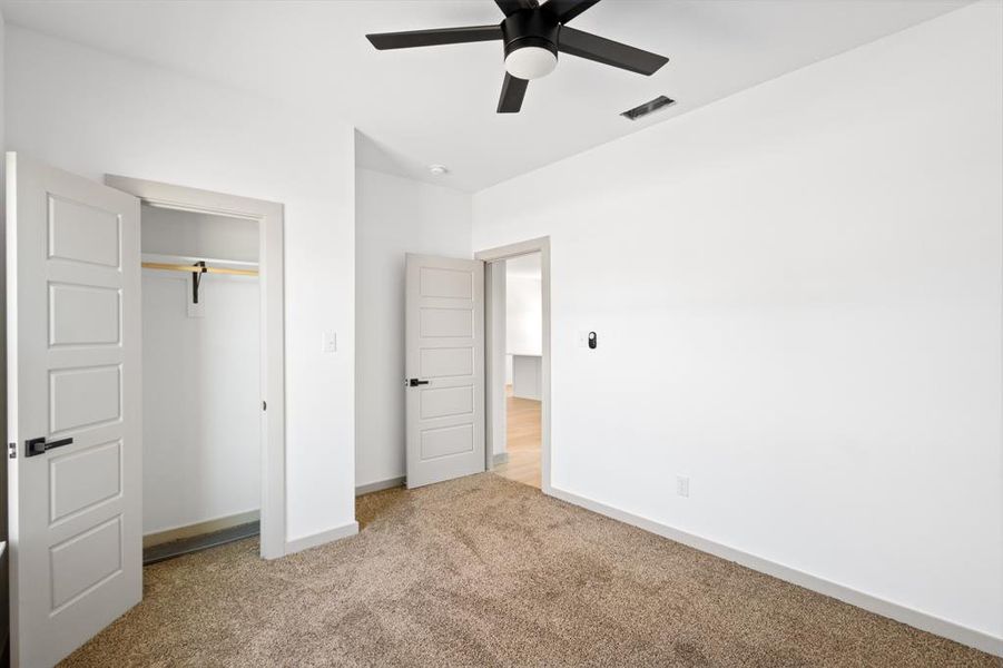 Unfurnished bedroom with baseboards, visible vents, a closet, ceiling fan, and carpet floors Unfurnished bedroom with baseboards, visible vents, a closet, ceiling fan, and carpet floors