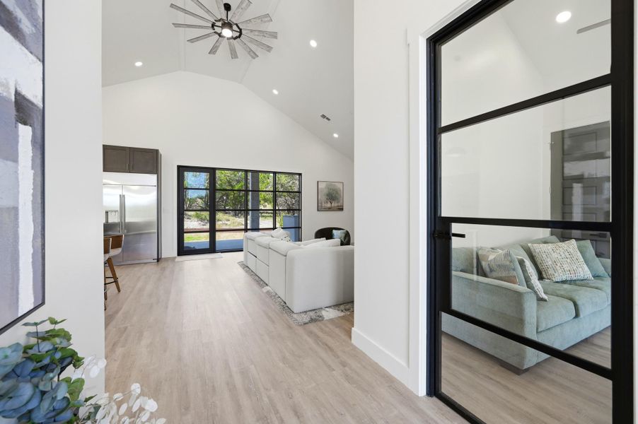 Gleaming wood floors anchor an airy open layout under a soaring vaulted ceiling.