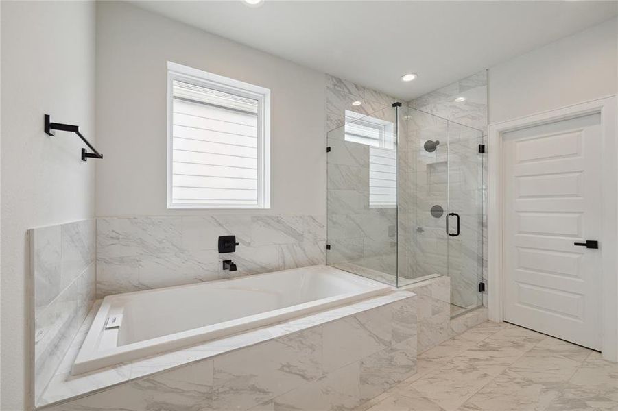 Relax and rejuvenate in style with the beautifully designed separate soaking tub and shower. The sleek, frameless shower door enhances the bathroom's features, creating a spacious and luxurious feel.