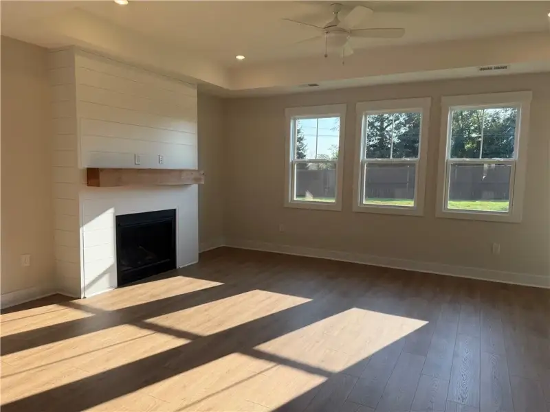 Warm wood flooring and a classic fireplace create