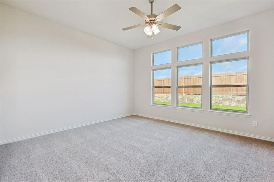 Carpeted empty room featuring ceiling fan