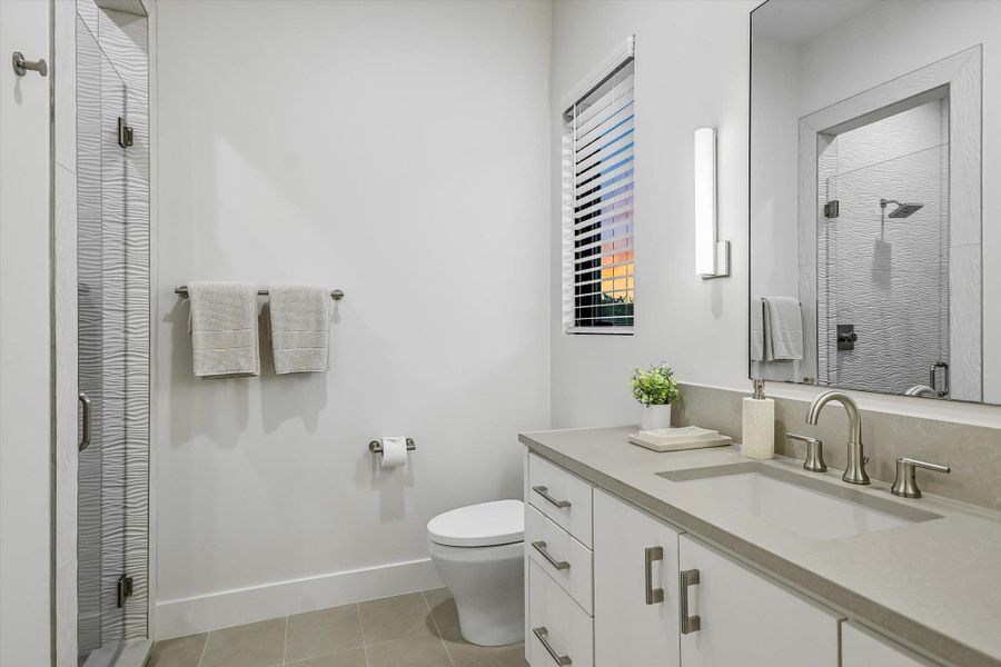 Full bathroom featuring a stall shower, vanity, and light tile patterned floors Full bathroom featuring a stall shower, vanity, and light tile patterned floors