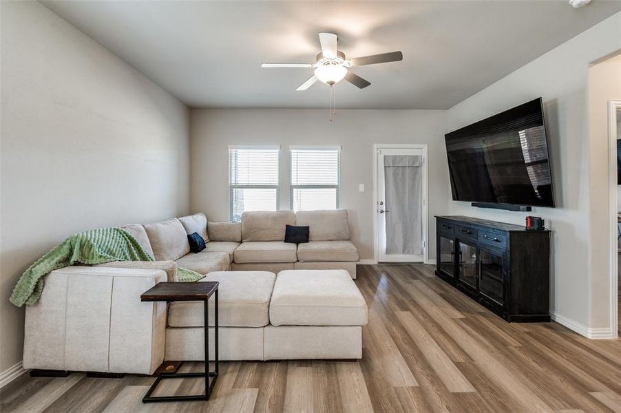 Living room with ceiling fan and light wood-style flooring