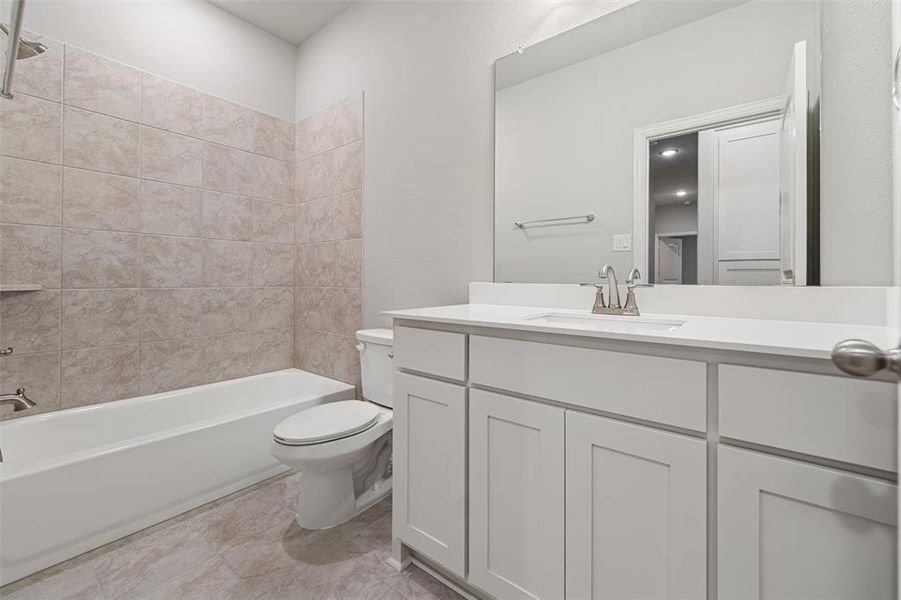Full bath with shower / bath combination, vanity, and light tile patterned floors Full bath with shower / bath combination, vanity, and light tile patterned floors