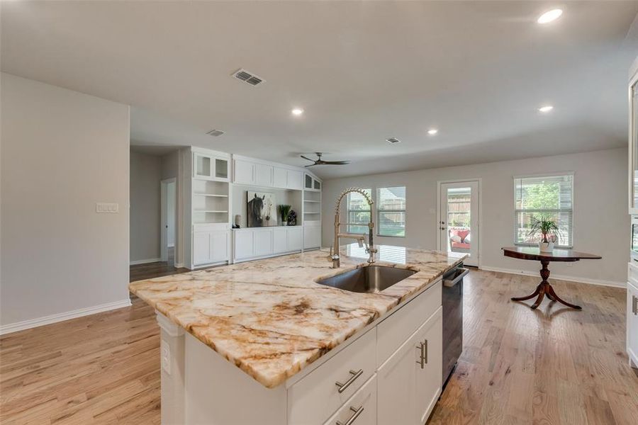 Kitchen featuring exotic granite countertop, white cabinetry, large sink with designer LED facet, a large island with pull out garbage and recycle drawer. Kitchen featuring exotic granite countertop, white cabinetry, large sink with designer LED facet, a large island with pull out garbage and recycle drawer.