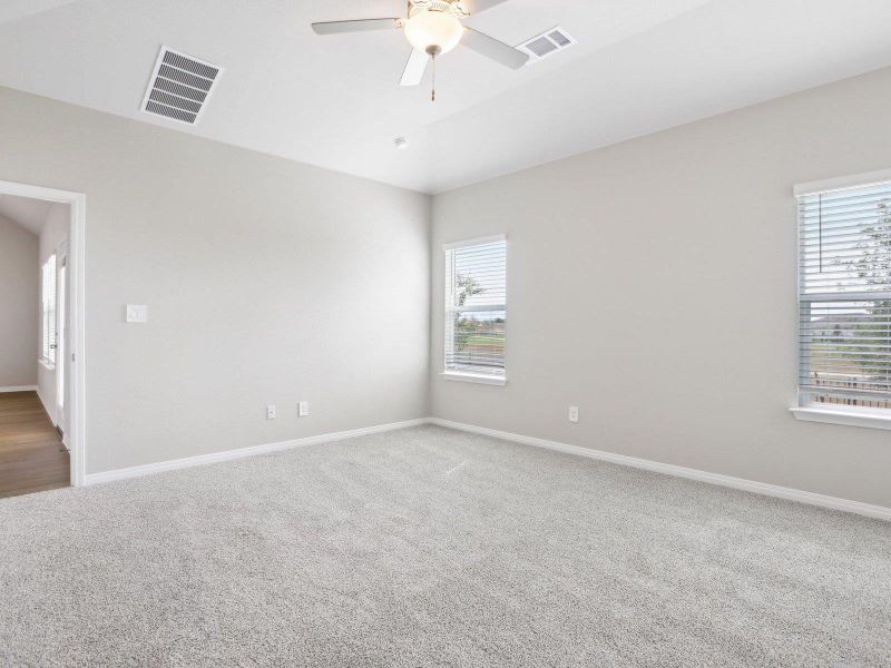Empty room with ceiling fan, carpet, baseboards, and vaulted ceiling Empty room with ceiling fan, carpet, baseboards, and vaulted ceiling