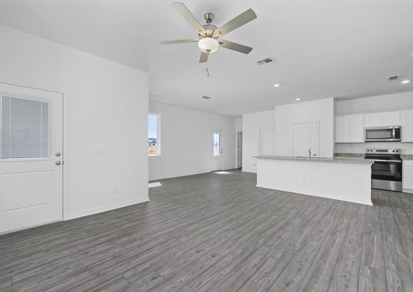 The open-concept entertainment space includes the family room, kitchen and dining room