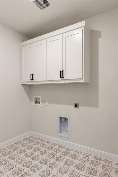 Clothes washing area with hookup for a gas dryer, electric dryer hookup, cabinets, light tile patterned floors, and washer hookup