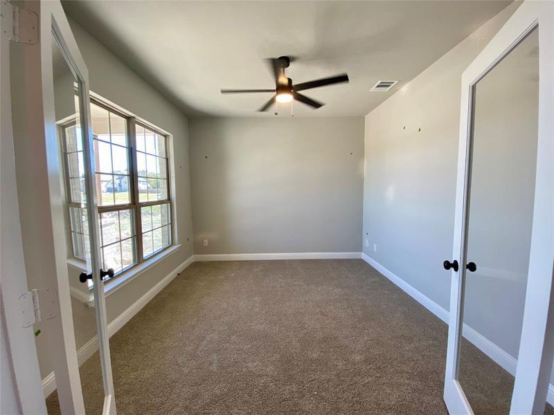 Bright study with modern glass double doors and ceiling fan