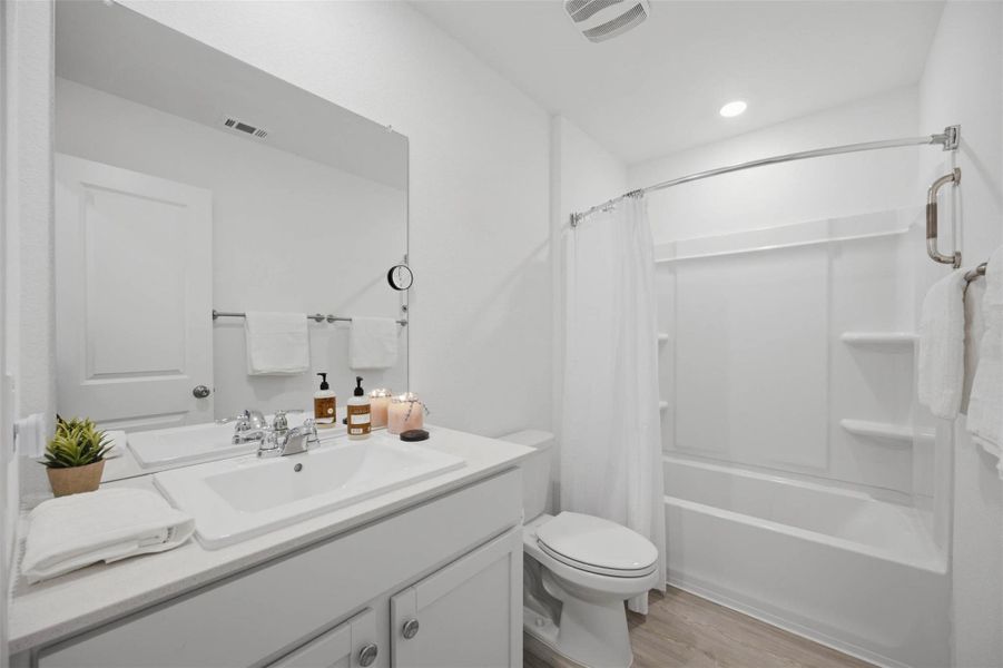 Crisp white finishes and a tub-shower combination define this functional bathroom space.