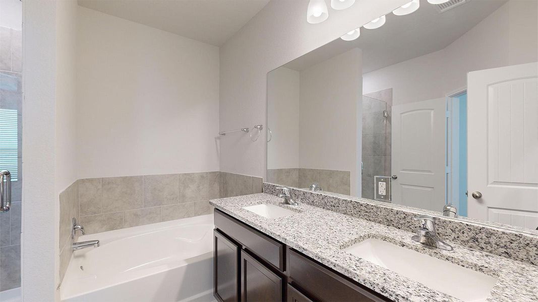 Full bath with a stall shower, a garden tub, and double vanity
