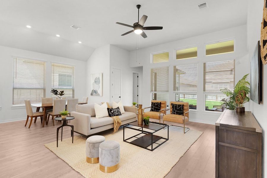 High vaulted ceilings and tall windows illuminate a spacious open living and dining area.