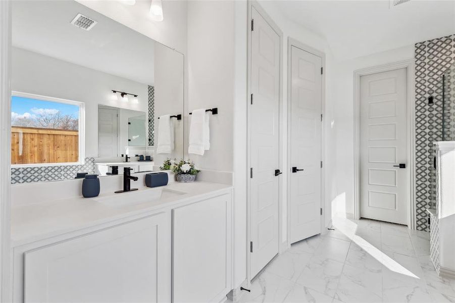 Bathroom with tasteful backsplash, vanity, and an enclosed shower