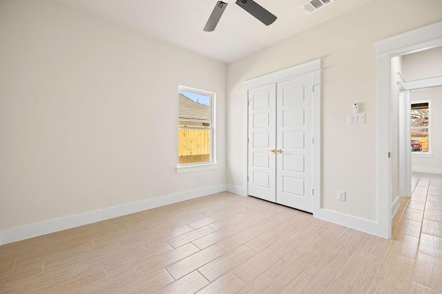 Unfurnished bedroom featuring baseboards, visible vents, ceiling fan, light wood-style floors, and a closet