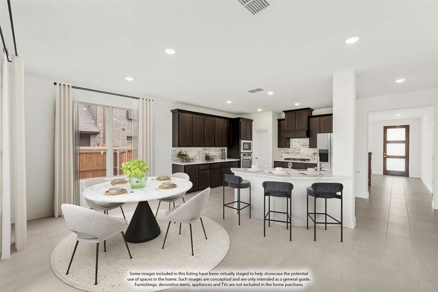 Open-plan kitchen and dining area with dark wood cabinets, white island with bar stools, and round dining table Open-plan kitchen and dining area with dark wood cabinets, white island with bar stools, and round dining table