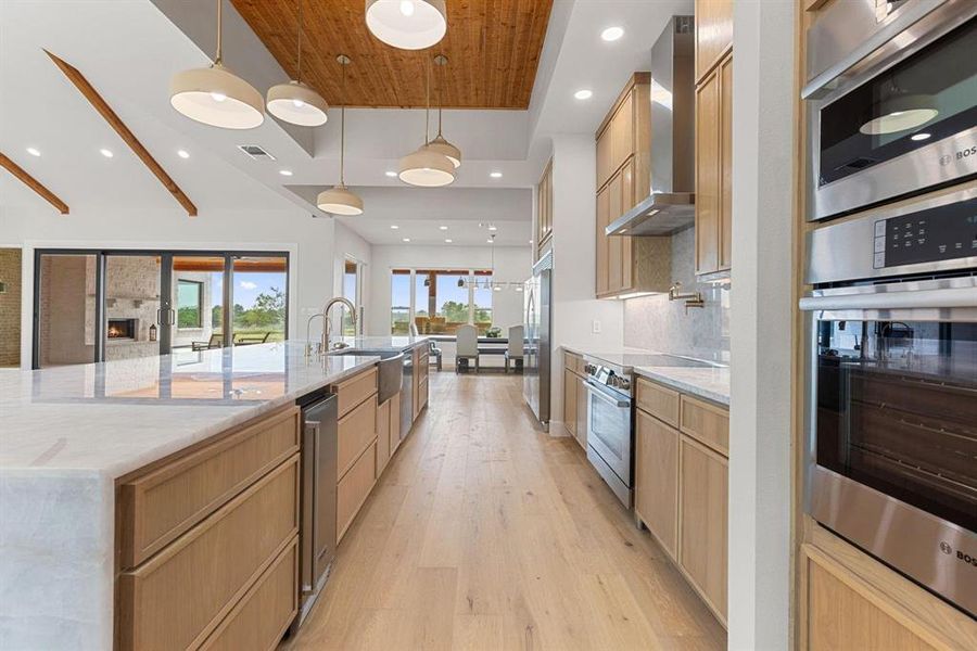 Kitchen with light stone countertops, light wood
finished floors, decorative light fixtures, recessed
lighting, and stainless steel appliances Kitchen with light stone countertops, light wood
finished floors, decorative light fixtures, recessed
lighting, and stainless steel appliances