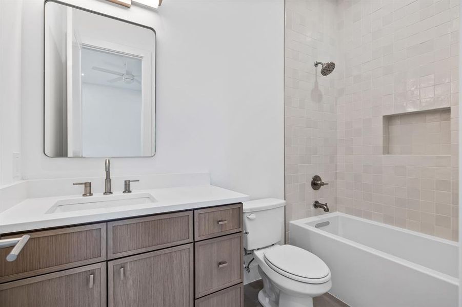 Full bathroom featuring vanity, toilet, and tiled shower / bath combo