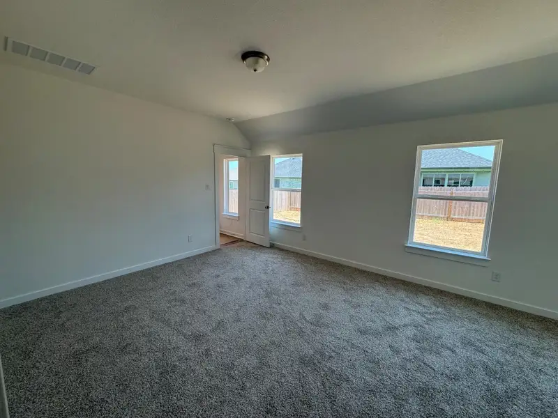 Carpeted spare room with baseboards and lofted ceiling Carpeted spare room with baseboards and lofted ceiling