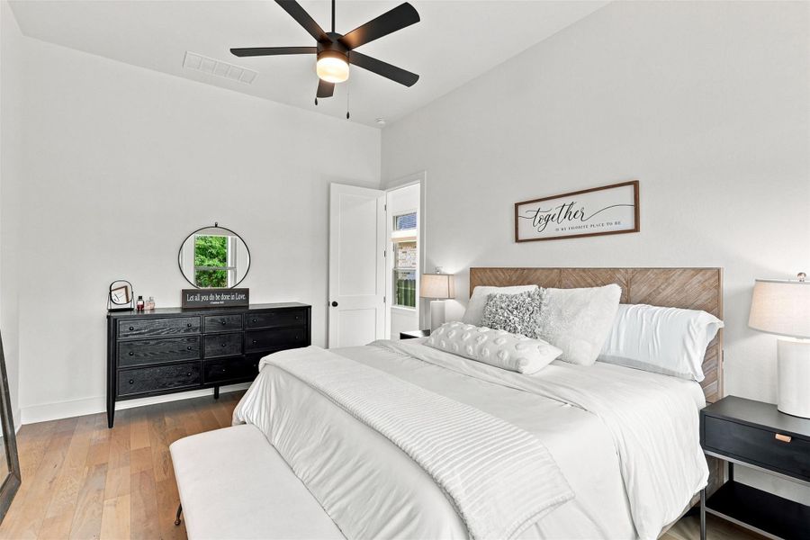 Gleaming hardwood floors and a lofty ceiling elevate this airy bedroom retreat.