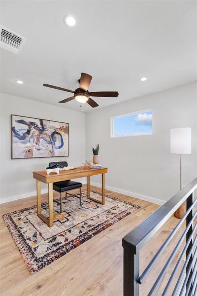 Office with light wood finished floors, ceiling fan, and recessed lighting