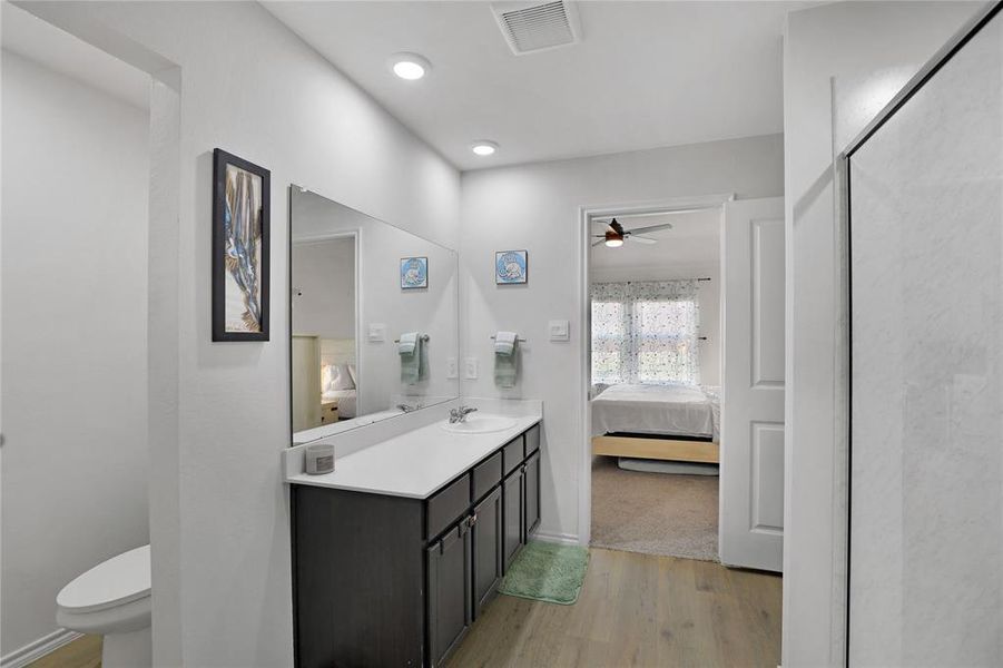 Ensuite bathroom with light wood-style floors, vanity, ceiling fan, a shower stall, and recessed lighting