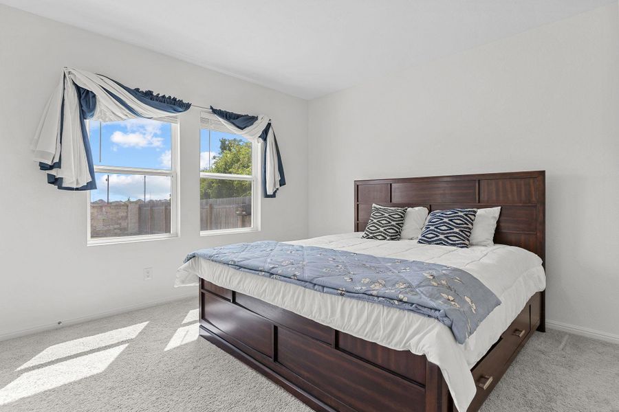 Bedroom featuring light colored carpet and baseboards Bedroom featuring light colored carpet and baseboards