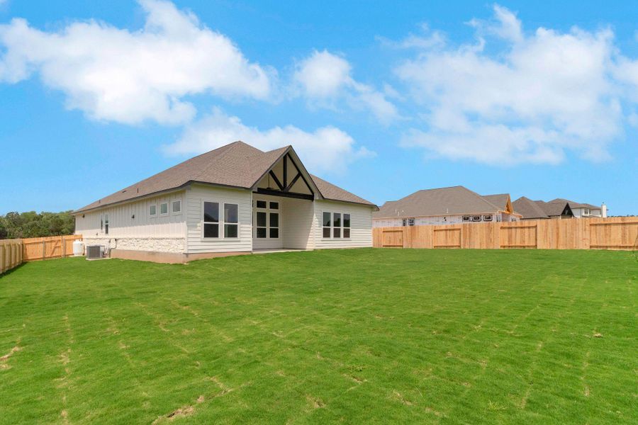 Rear view of property with a fenced backyard, a yard, and central AC