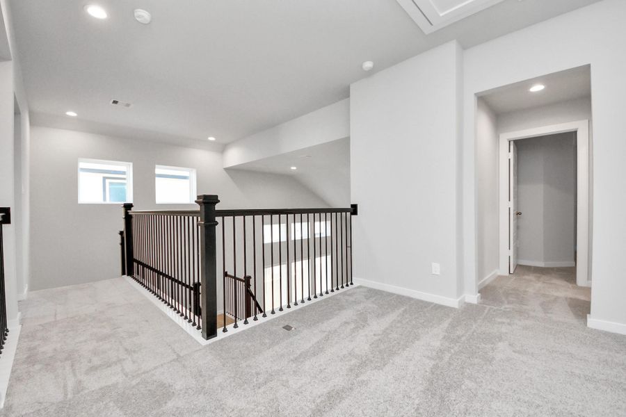 Come upstairs and enjoy a day of leisure in this fabulous game room! This is the perfect hangout spot or adult game room! Features plush carpet, high ceilings, custom paint and windows for plenty of natural light. Sample photo of completed home with similar floor plan. Actual colors and selections may vary. Come upstairs and enjoy a day of leisure in this fabulous game room! This is the perfect hangout spot or adult game room! Features plush carpet, high ceilings, custom paint and windows for plenty of natural light. Sample photo of completed home with similar floor plan. Actual colors and selections may vary.