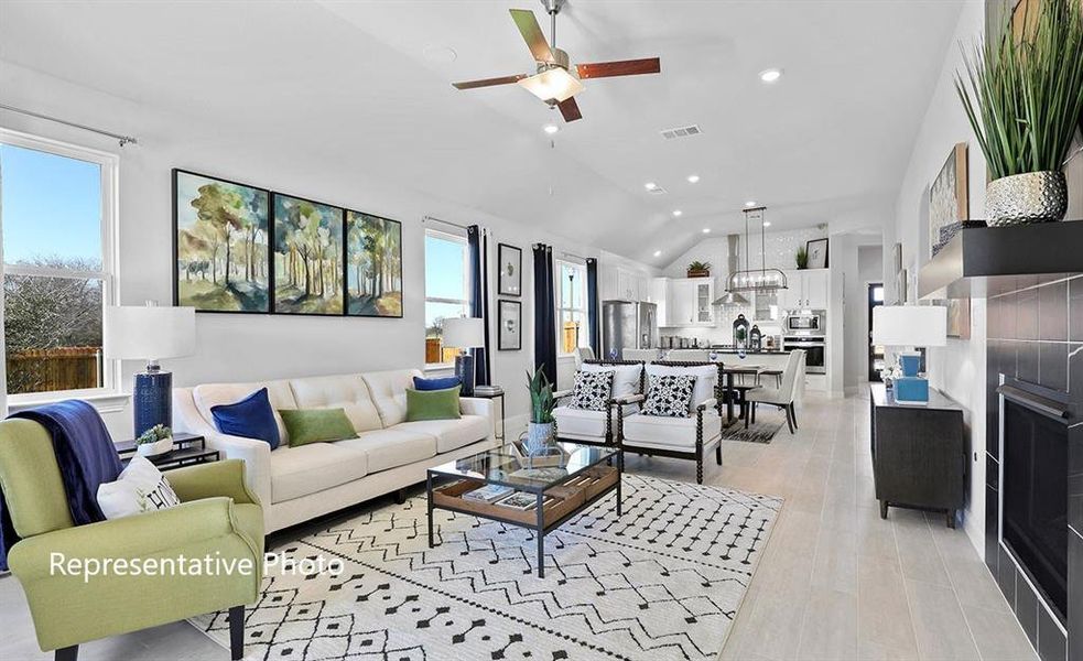 Open-concept living area featuring light wood-finish flooring, vaulted ceilings, and recessed lighting