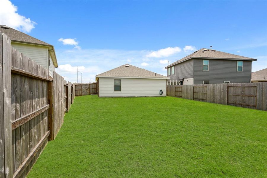 Head to the backyard to find plenty of green space to enjoy! Accessible at the side of the home through the living room, there is plenty of space to create an outdoor living space!