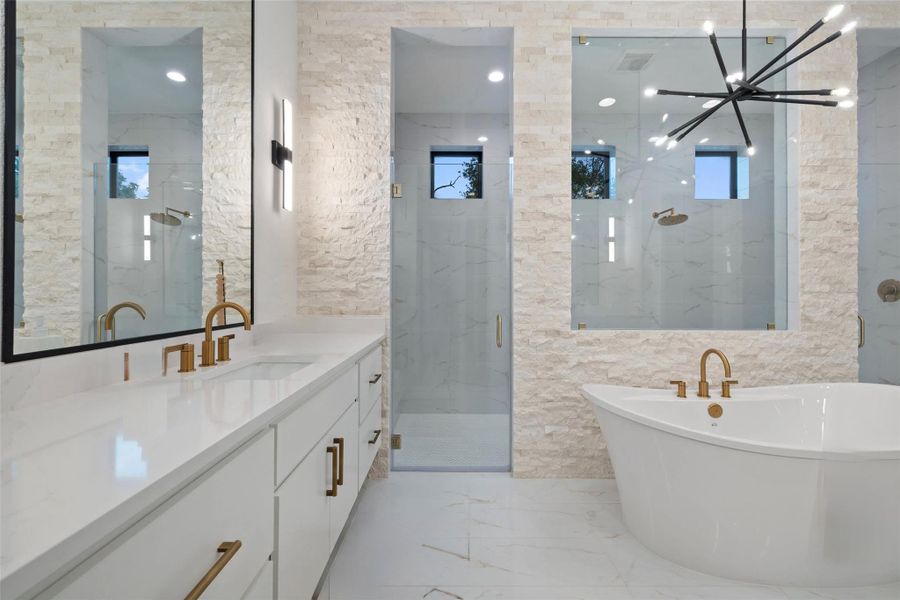 Contemporary bathroom featuring a freestanding soaking tub, dual vanities with white countertops, and expansive walk-in showers with glass enclosures