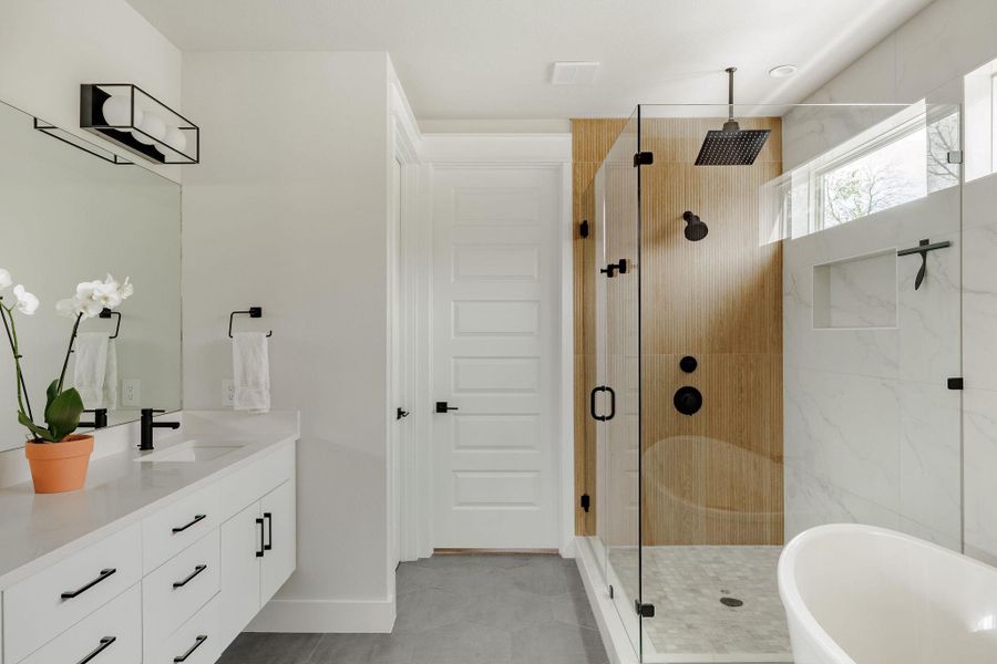 Bathroom with vanity, a freestanding bath, and a stall shower