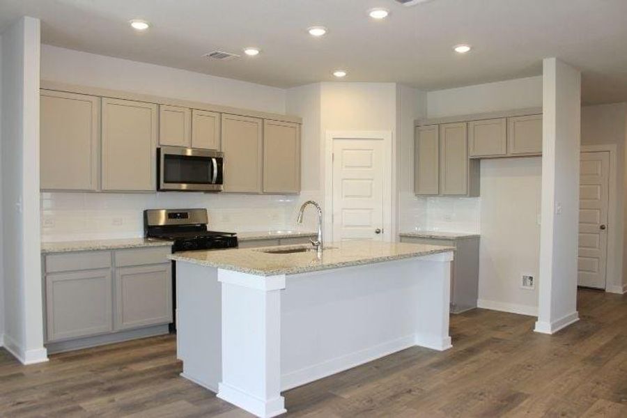 Kitchen with gray cabinets, stainless steel appliances, backsplash, dark wood-style flooring, and recessed lighting