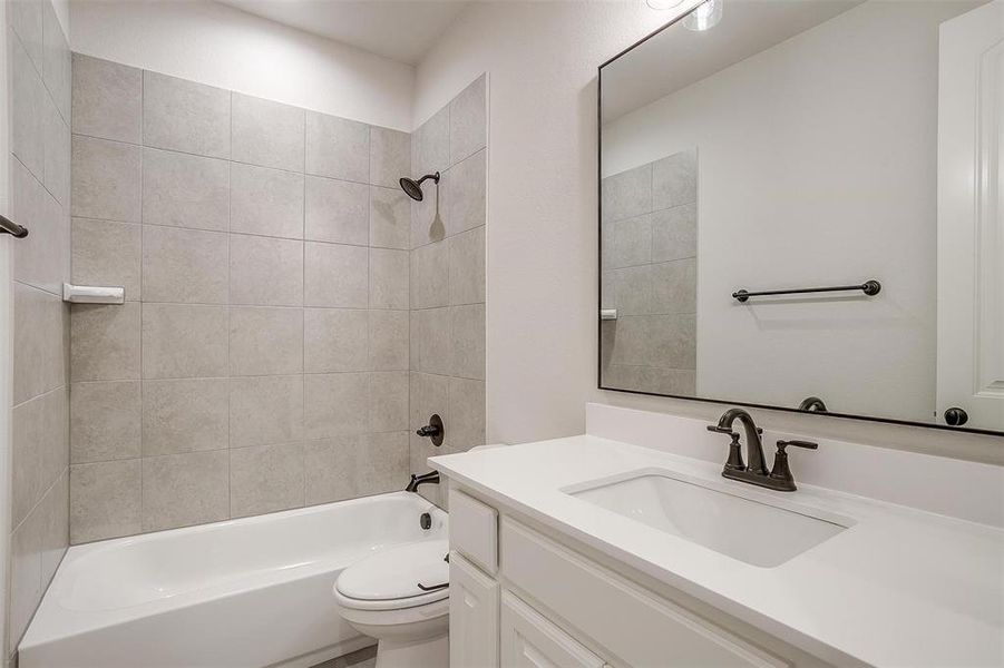 Full bathroom featuring vanity, toilet, and tiled shower / bath