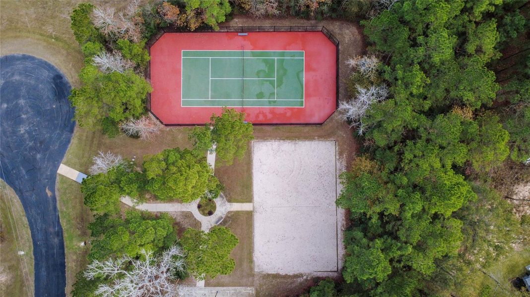 Exceptional recreational facilities including a pristine tennis court and a professional-grade sand volleyball court, all tucked away in a quiet, wooded setting.