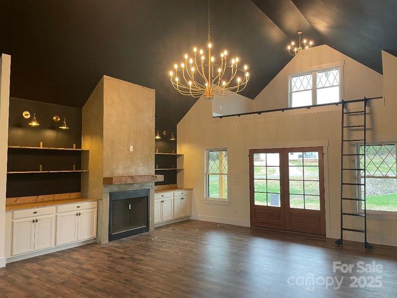 A Family Room like no other with designs from floor to ceiling, built-ins, custom loft with ladder above the front door, beautiful lighting and wood accents around the room.