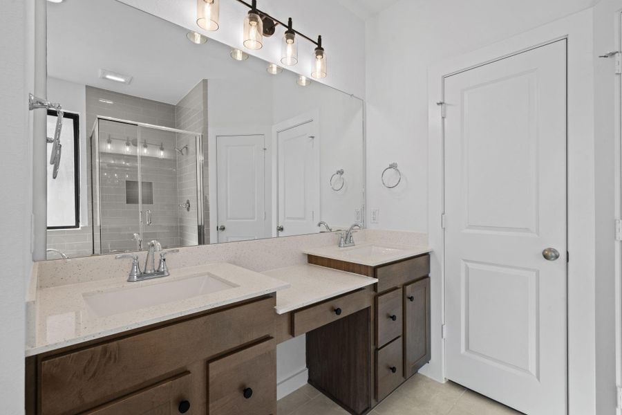 Convenient double sink with a vanity in the main bathroom offers both functionality and style, featuring two basins set into a spacious countertop that allows simultaneous use.