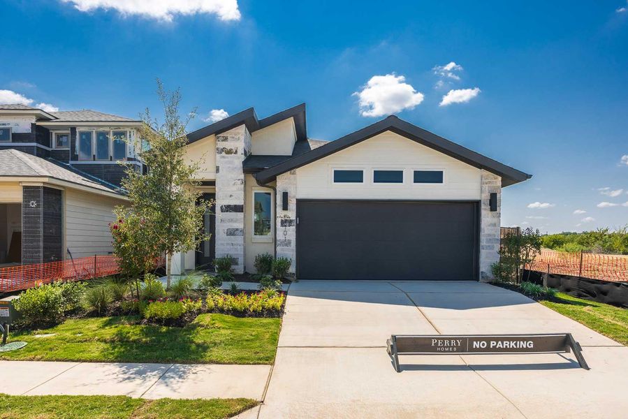 View of front of house with concrete driveway and a garage