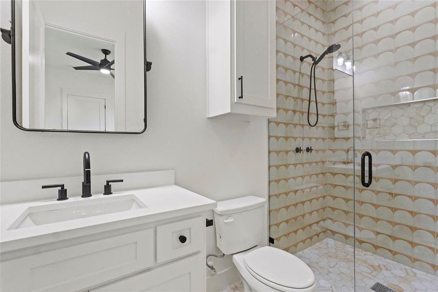 Bathroom with a stall shower, vanity, and a ceiling fan Bathroom with a stall shower, vanity, and a ceiling fan