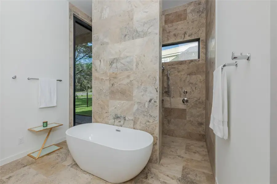 Indulge in a tranquil bathing experience with this deep soaking tub and tiled shower enclosure.