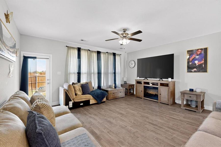Living area featuring light wood-style floors and a ceiling fan Living area featuring light wood-style floors and a ceiling fan