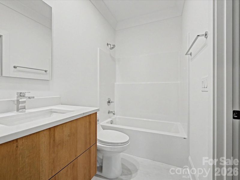 Bright full bathroom featuring a modern vanity, sleek fixtures, and a tub/shower combination with clean, contemporary finishes.