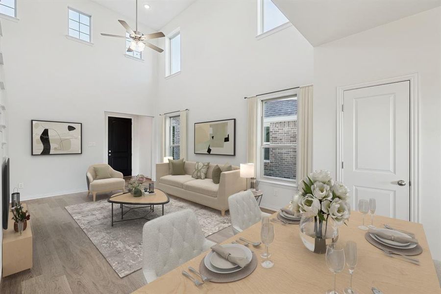 Living area with wood finished floors, a high ceiling, ceiling fan, and baseboards Living area with wood finished floors, a high ceiling, ceiling fan, and baseboards