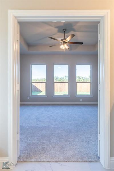 Carpeted empty room featuring a ceiling fan