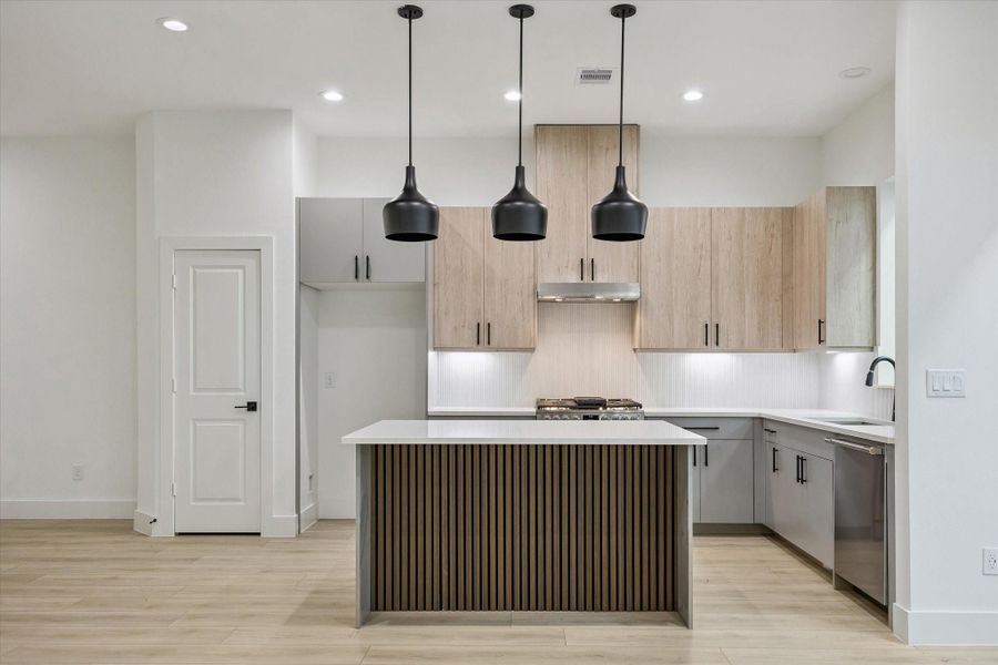 Oversized kitchen island with pendant lighting and premium finishes Oversized kitchen island with pendant lighting and premium finishes