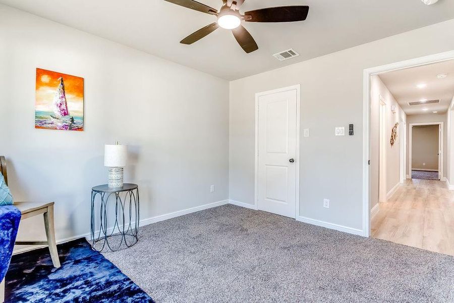 Carpeted bedroom with ceiling fan