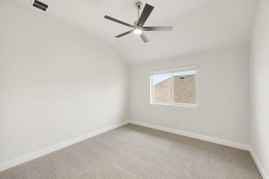 Empty bedroom with vaulted ceiling, ceiling fan, carpet flooring, and single window